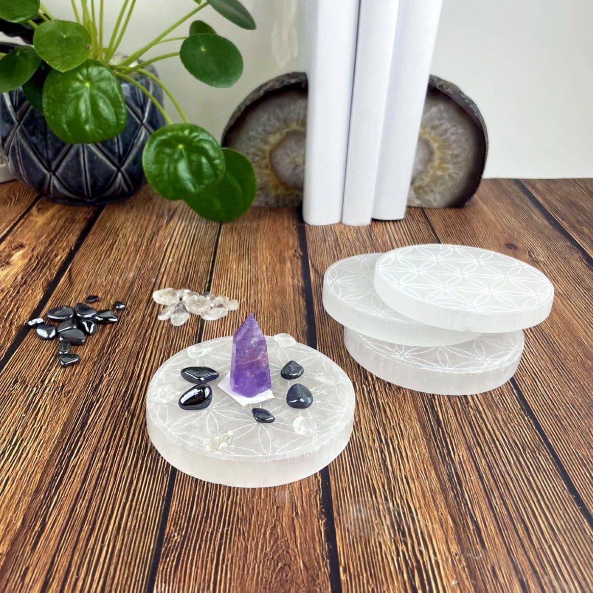 selenite round plate engraved with flower of life with charging stones and others on display