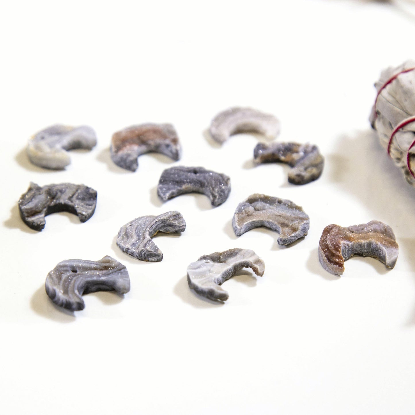 Angled shot of 9 Raw Chalcedony Moon Crescents on white background