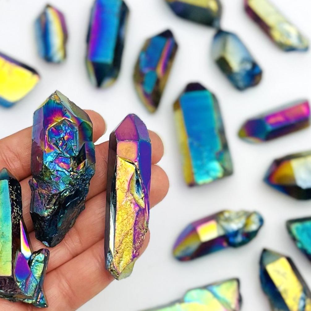 crystal quartz points coated in rainbow titanium showing the different colors and size variations