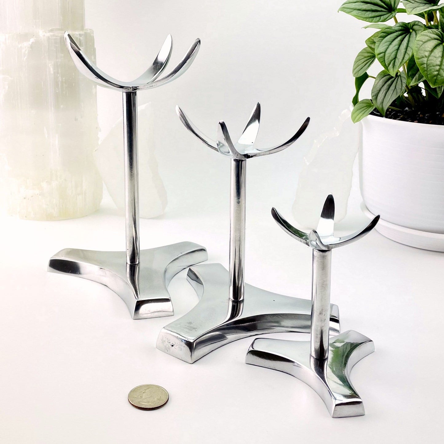 All three sizes of sphere holders on a white background with a quarter next to them showing they tower above the quarter.