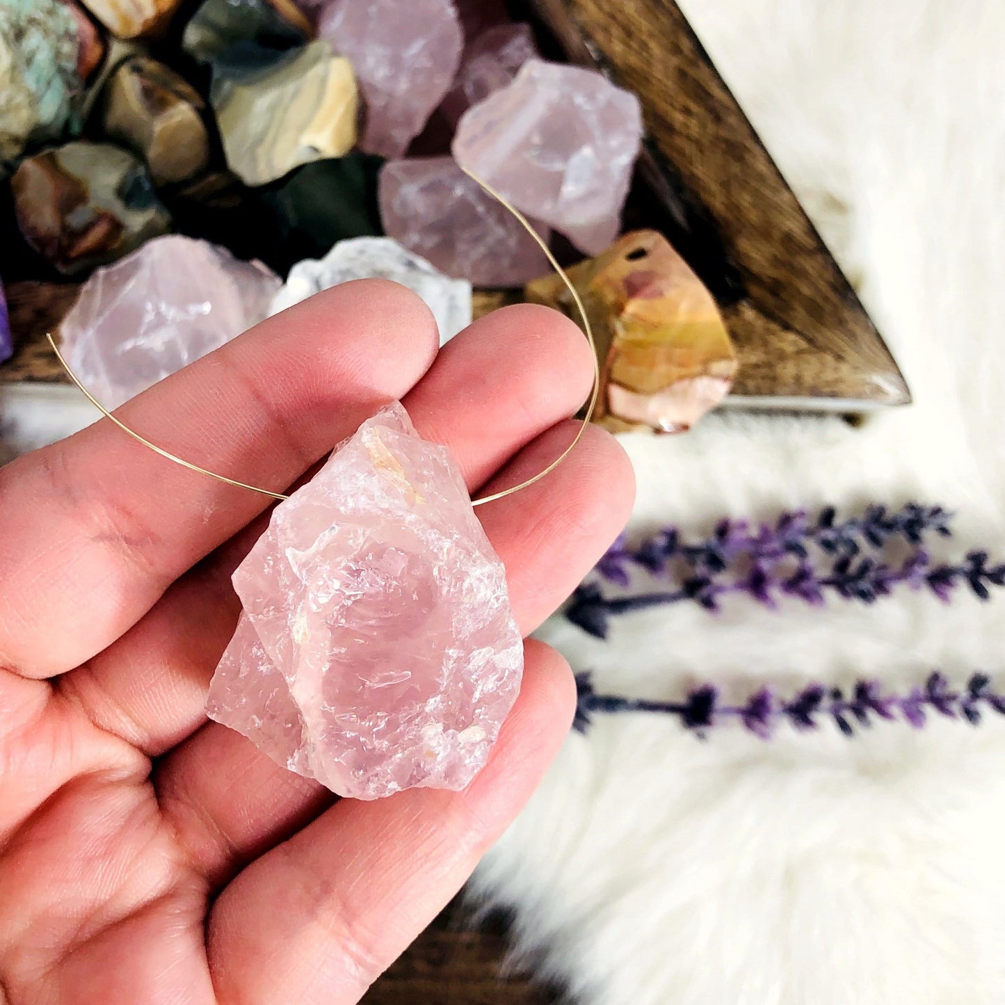 Rough Stone Bead with wire going through it with other beads in container blurred in the background