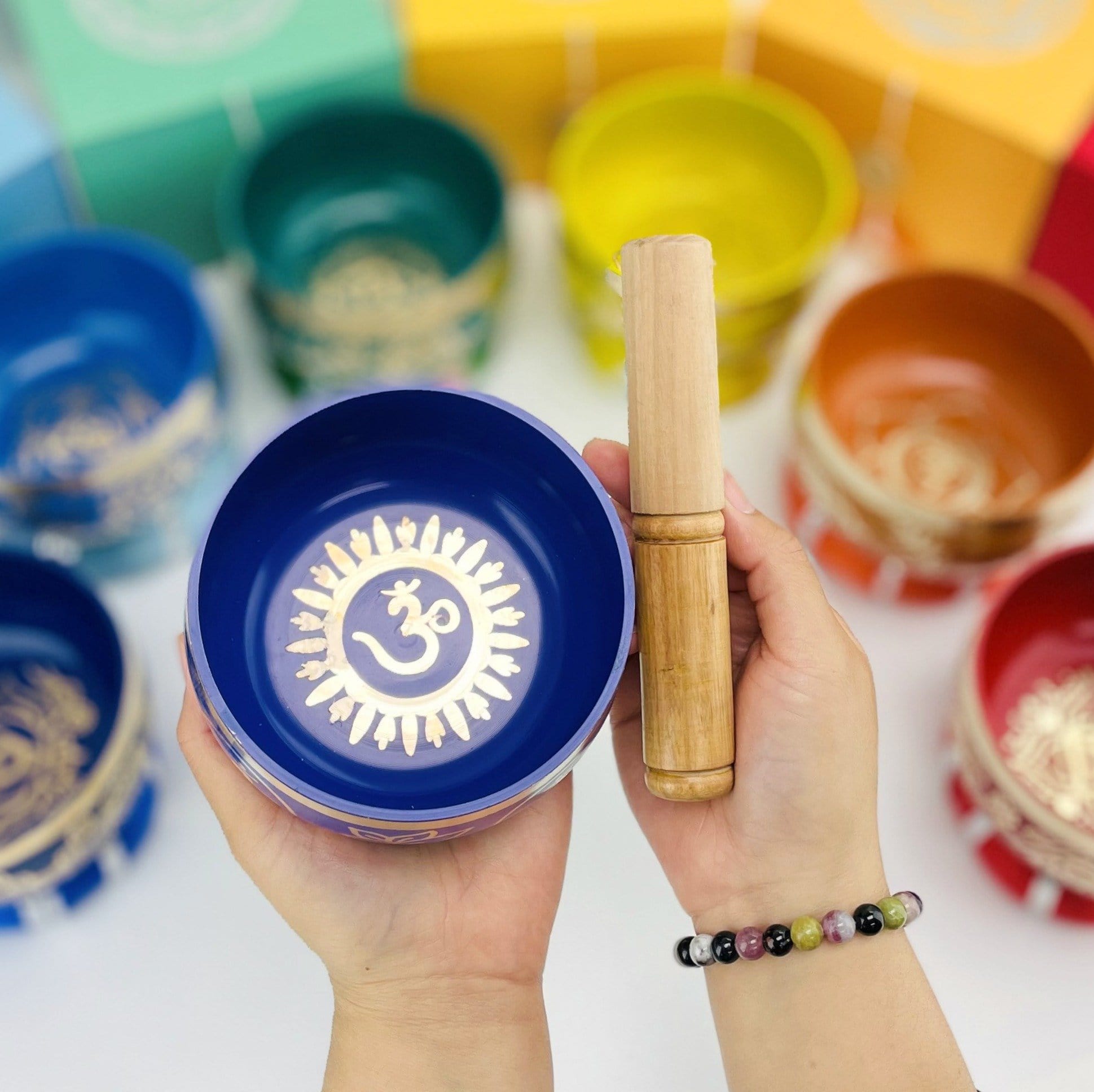 Brass Tibetan Singing Bowls - blue bowl in a hand with a mallet