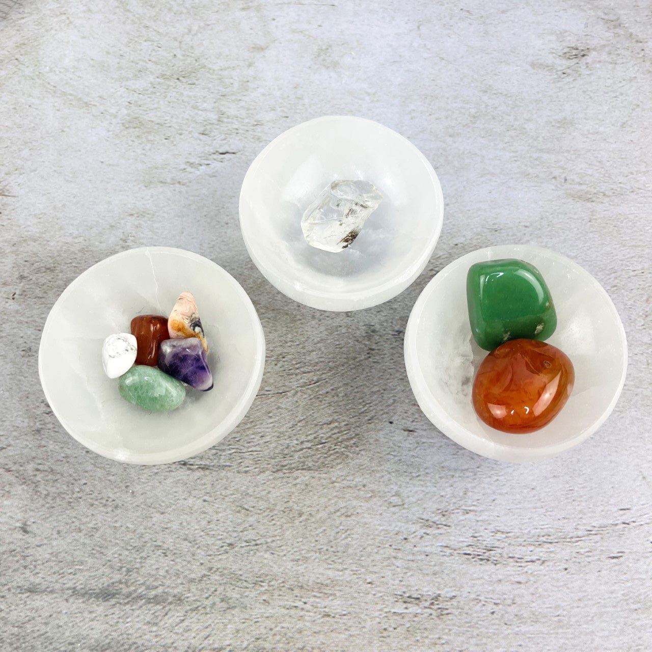 3 Selenite Bowls with stones inside, shot from above