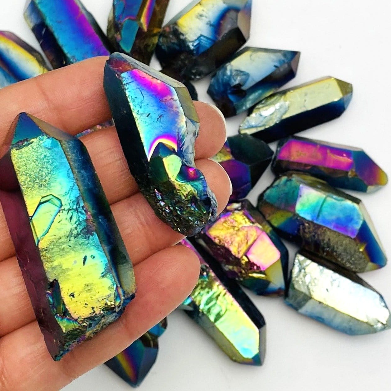 crystal quartz points coated in rainbow titanium showing the different colors and size variations