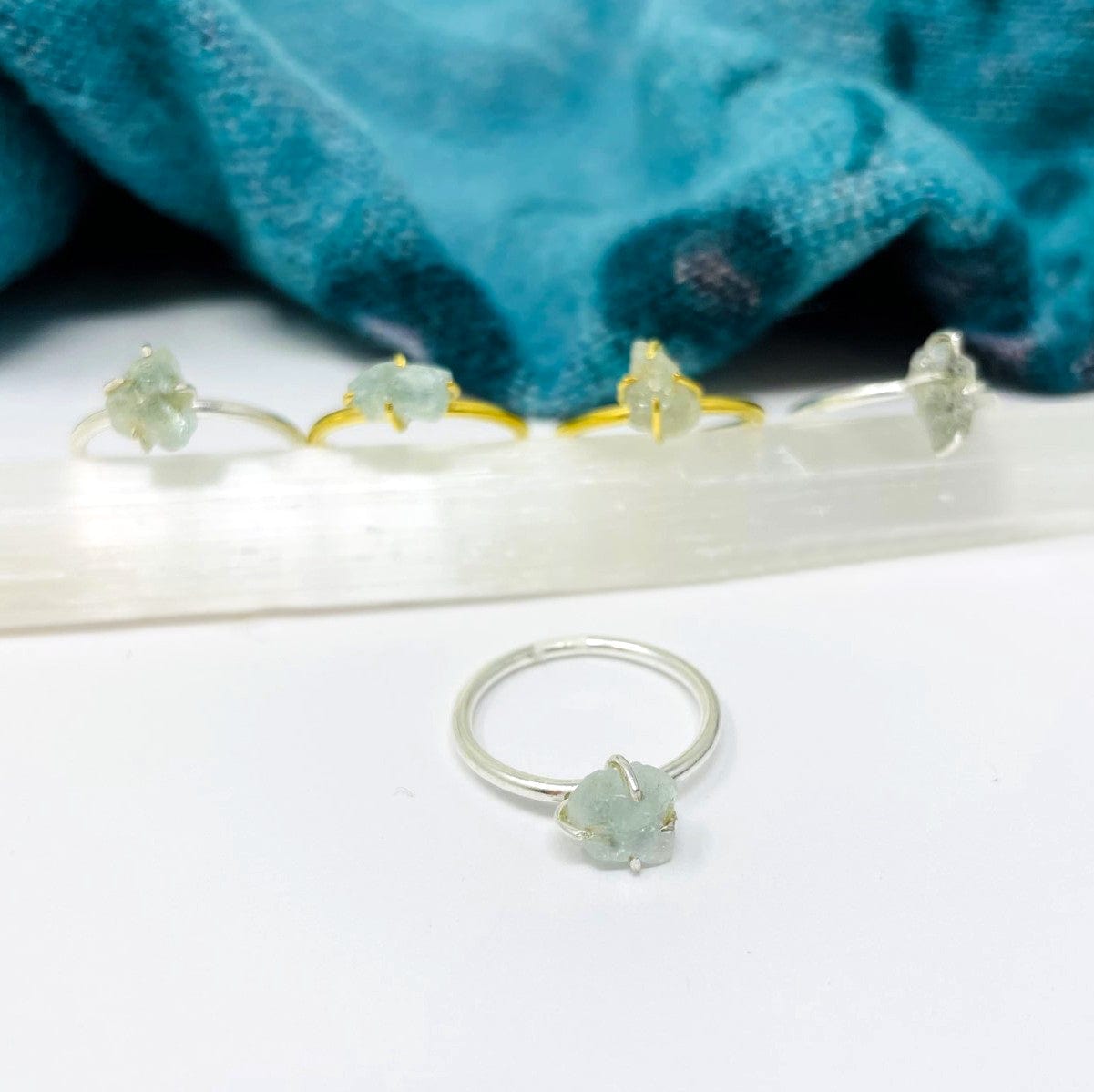 multiple aquamarine gemstone rings displayed to show the slight differences in the colors