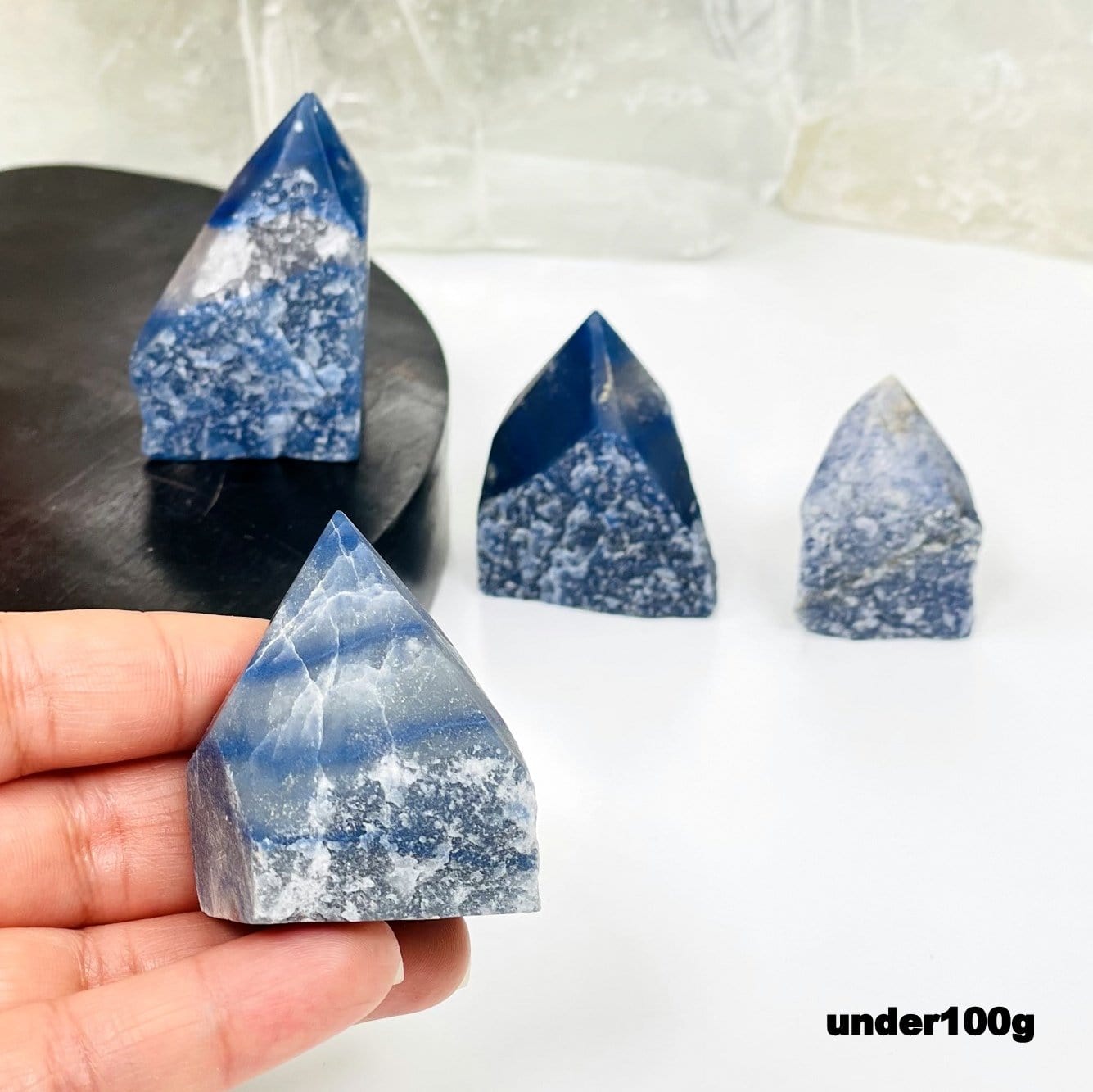 blue quartz point in hand for size reference 