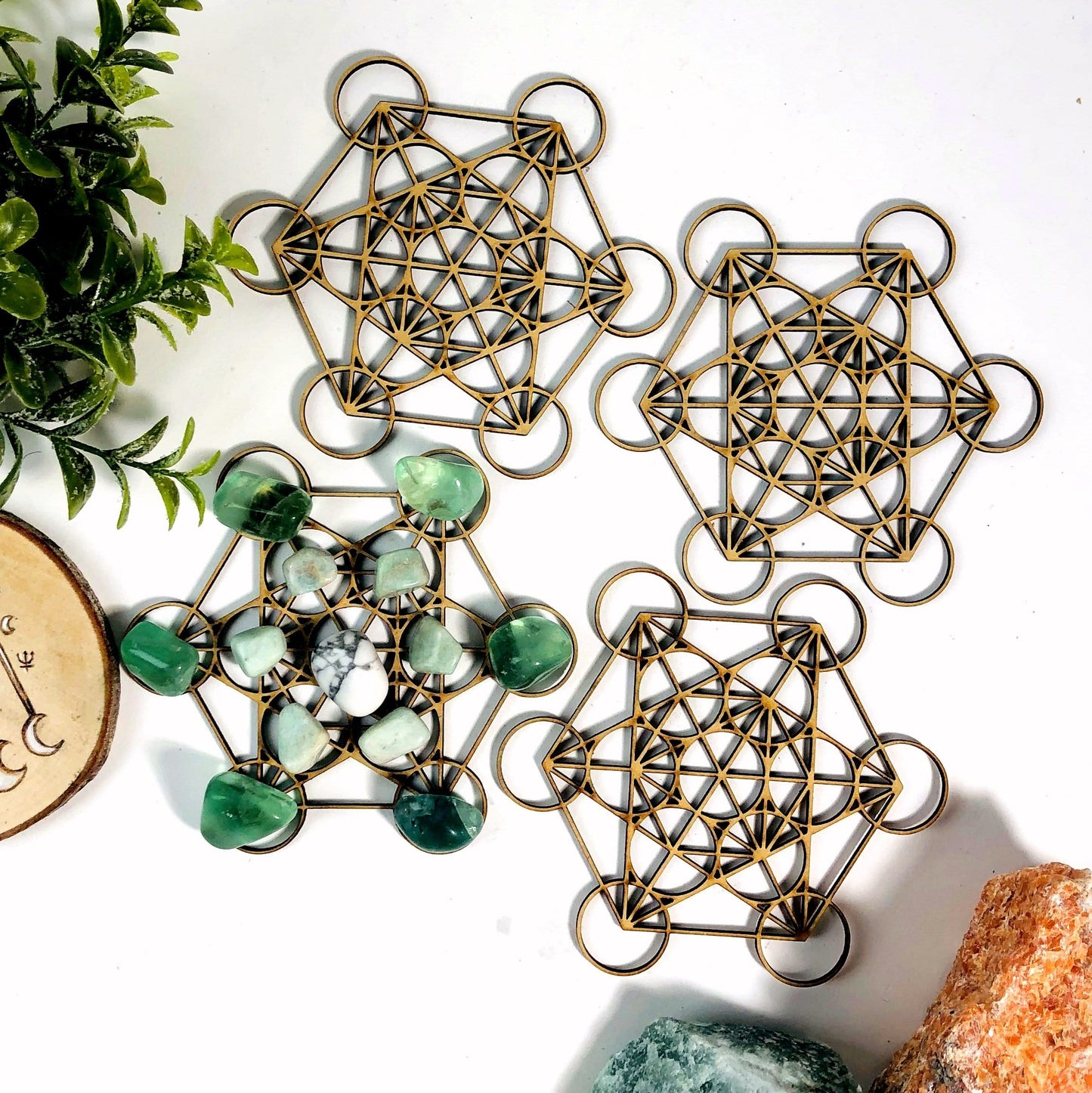 4 metatron crystal grids one with stones on it on white background with decorations