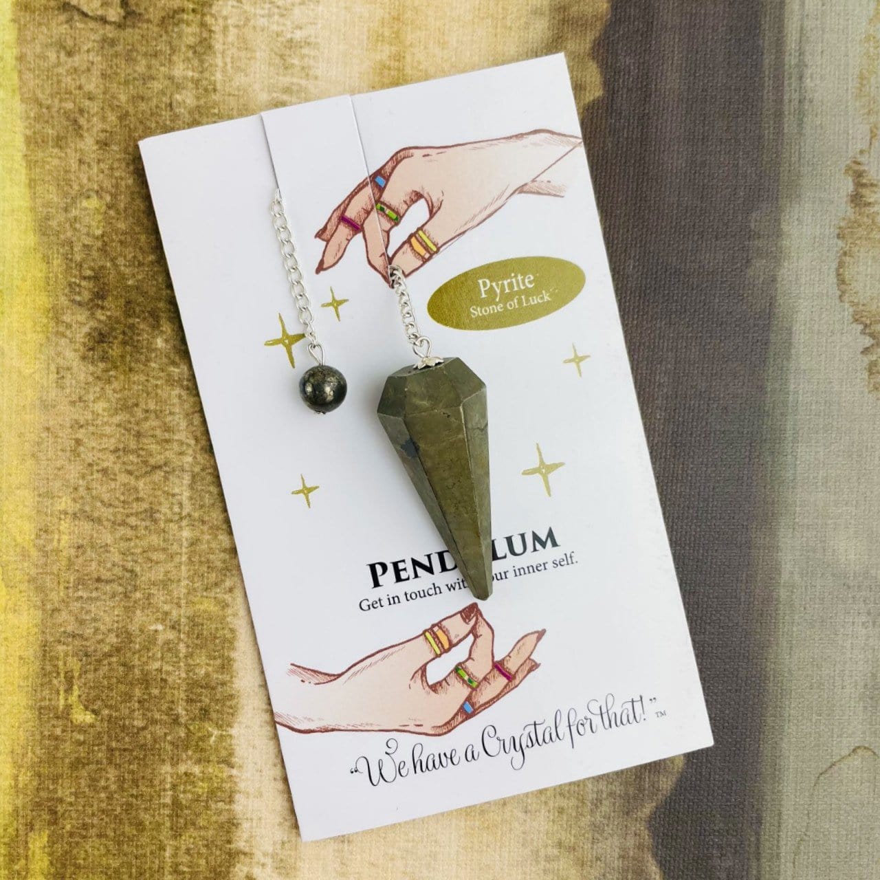 pyrite crystal pendulum on information card