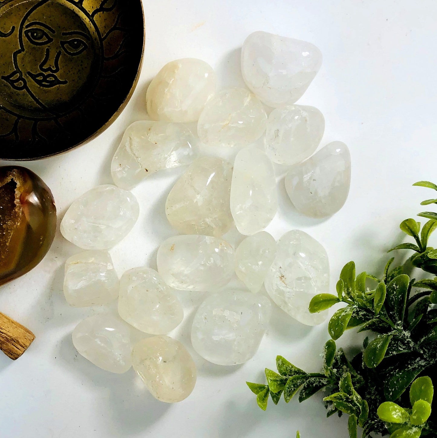 Crystal Quartz tumbled stones on a white background.