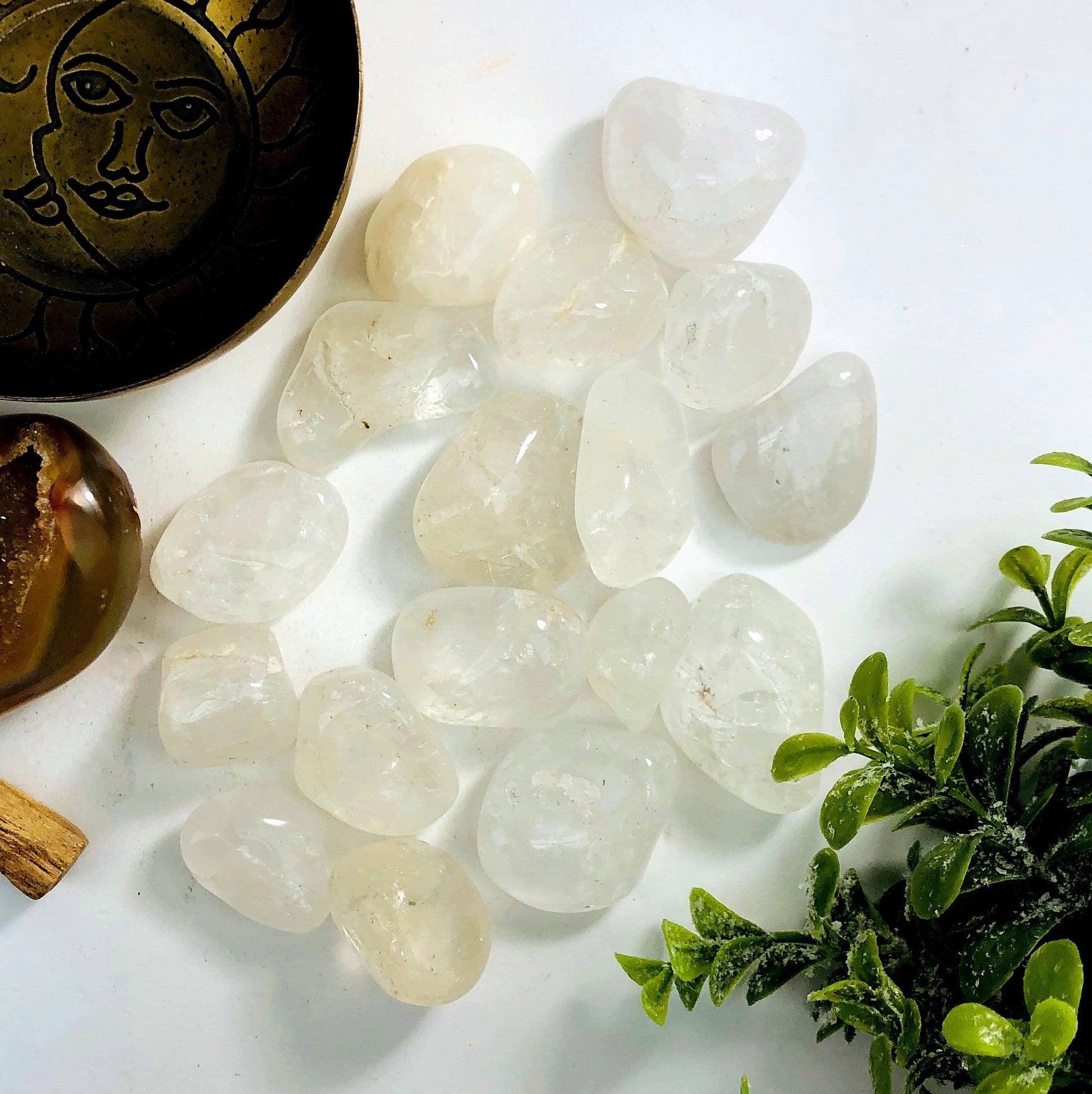 Crystal Quartz tumbled stones on a white background.