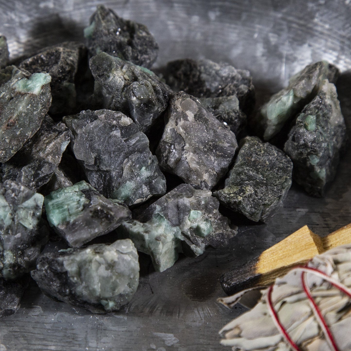 emerald rough stones with decorations in the background