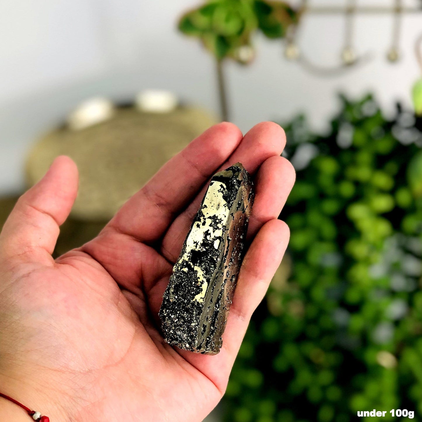 obelisk tower in a woman's hand showing off the druzy formations inside the piece