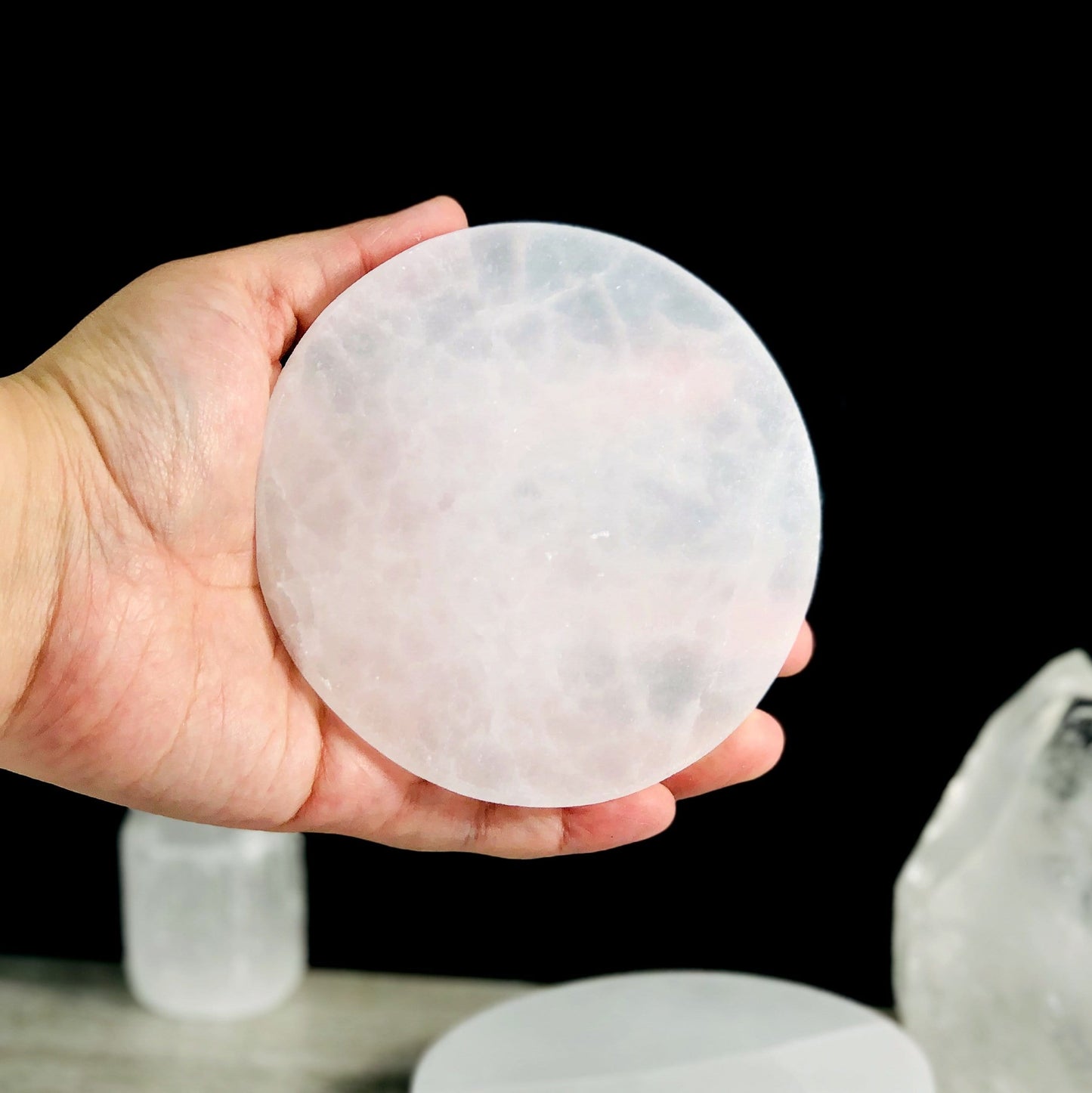 10cm round selenite charging plate in hand for size reference 