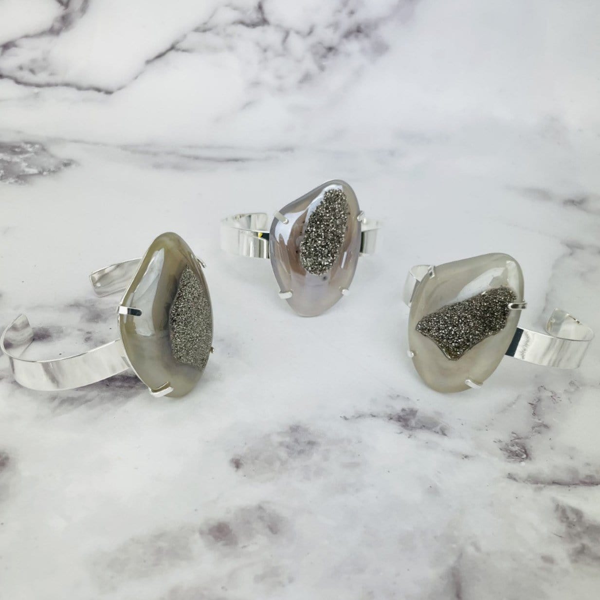 3 titanium druzy angel aura agate bracelets on marble background