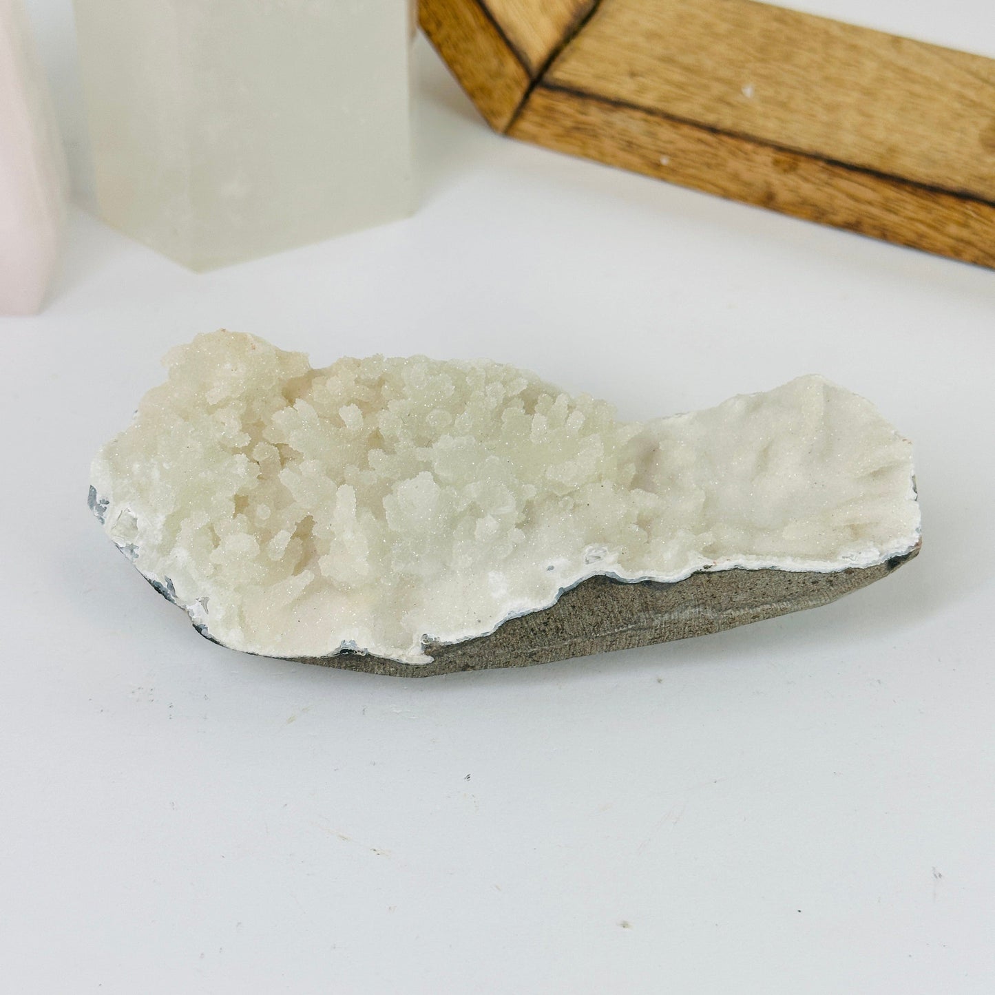 apophyllite on matrix with decorations in the background