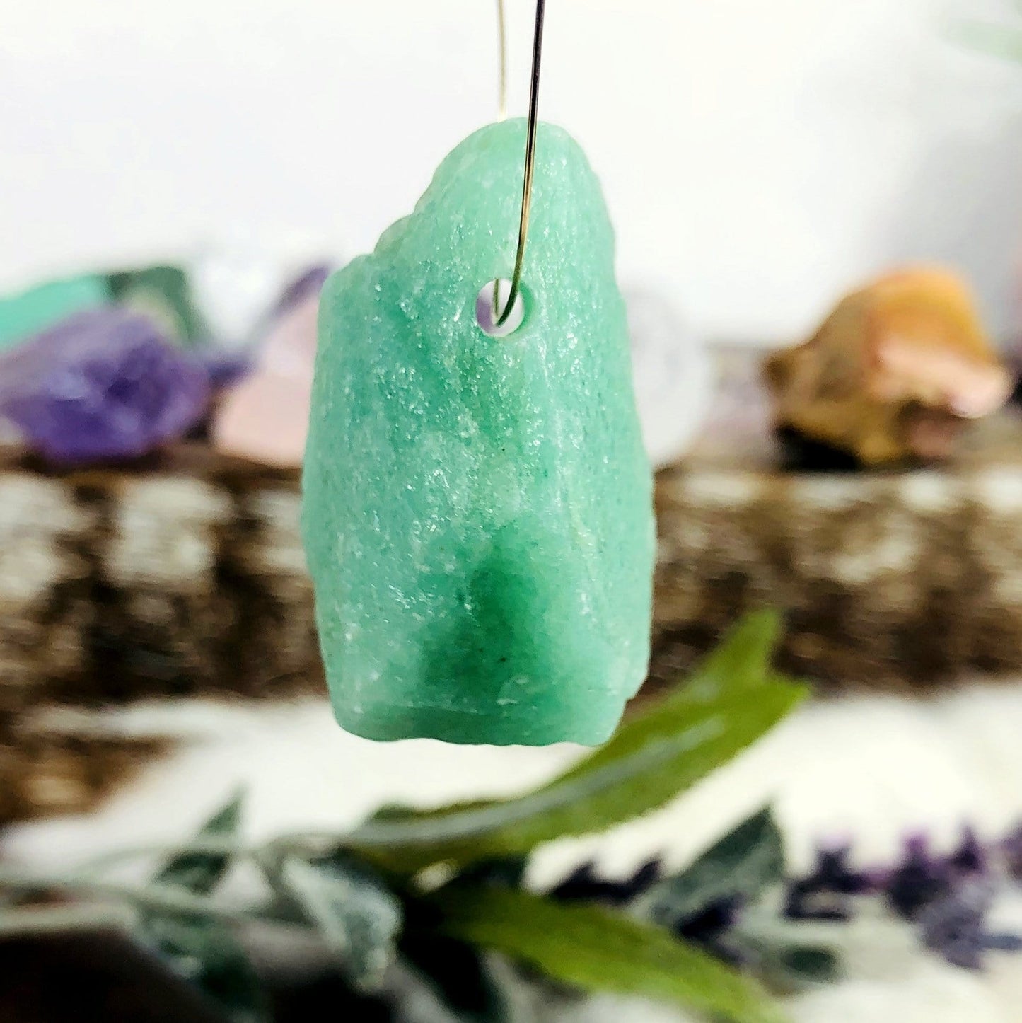 Rough Stone Bead with wire going through it with other beads blurred in the background