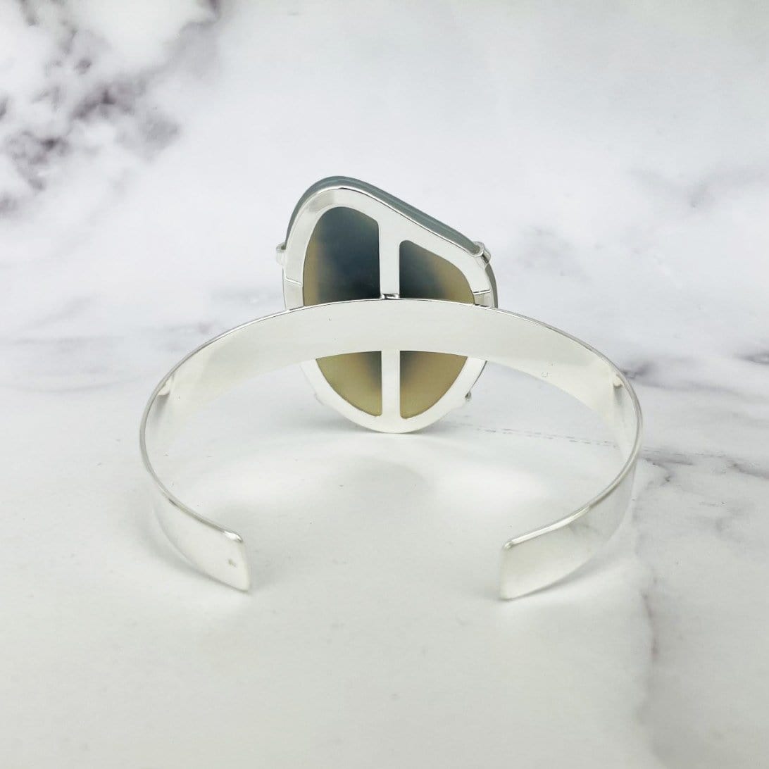 back view of titanium druzy angel aura agate bracelet on marble background