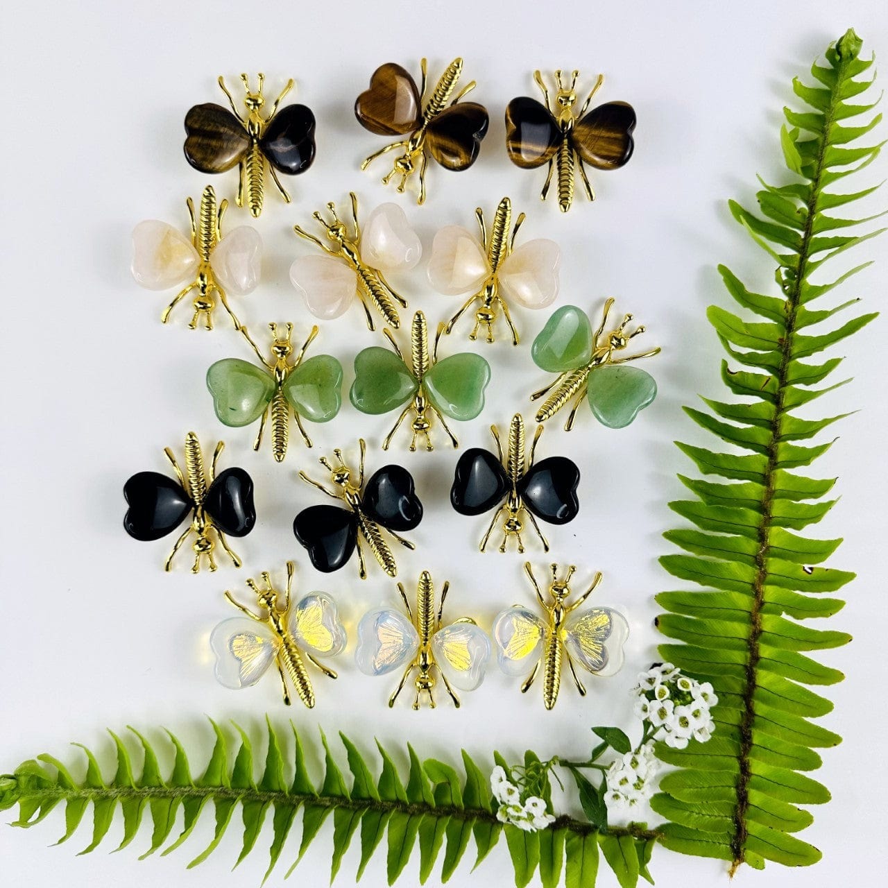 Gemstone Butterflies with Gold Tone Body on a table showing the assorted stones we carry from over head