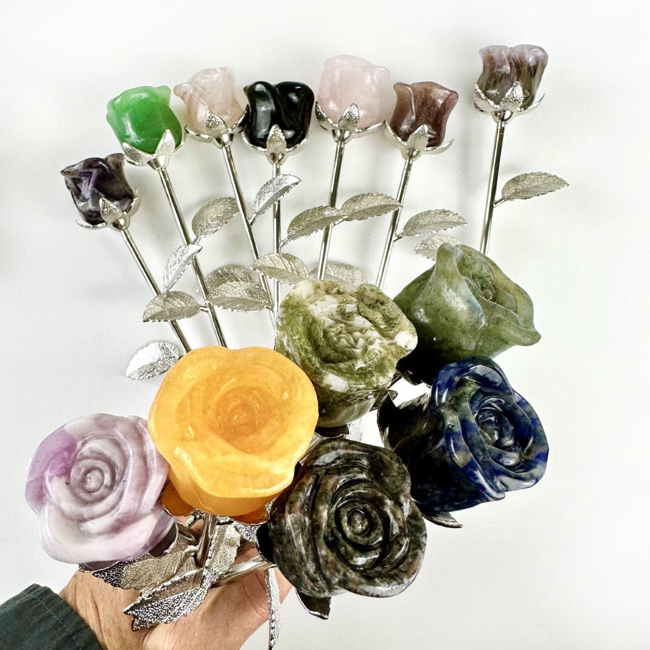 Crystal Rose - Carved Stones some in a hand and some in background on side