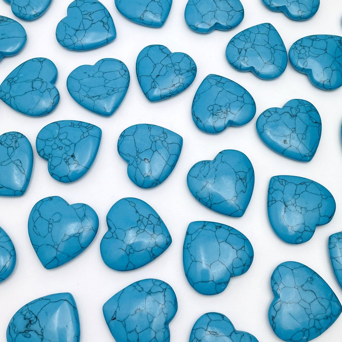 turquoise howlite hearts scattered across white background
