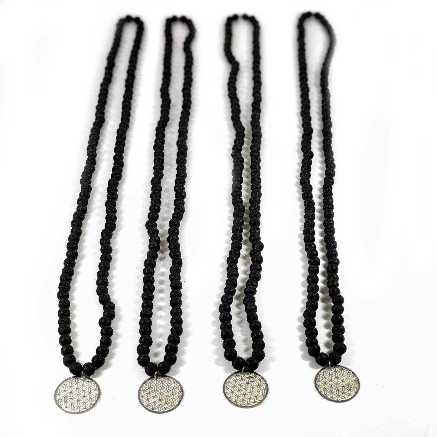 4 Diffuser Necklace Lava Bead with Flower of Life Charm in Silver on White Background.