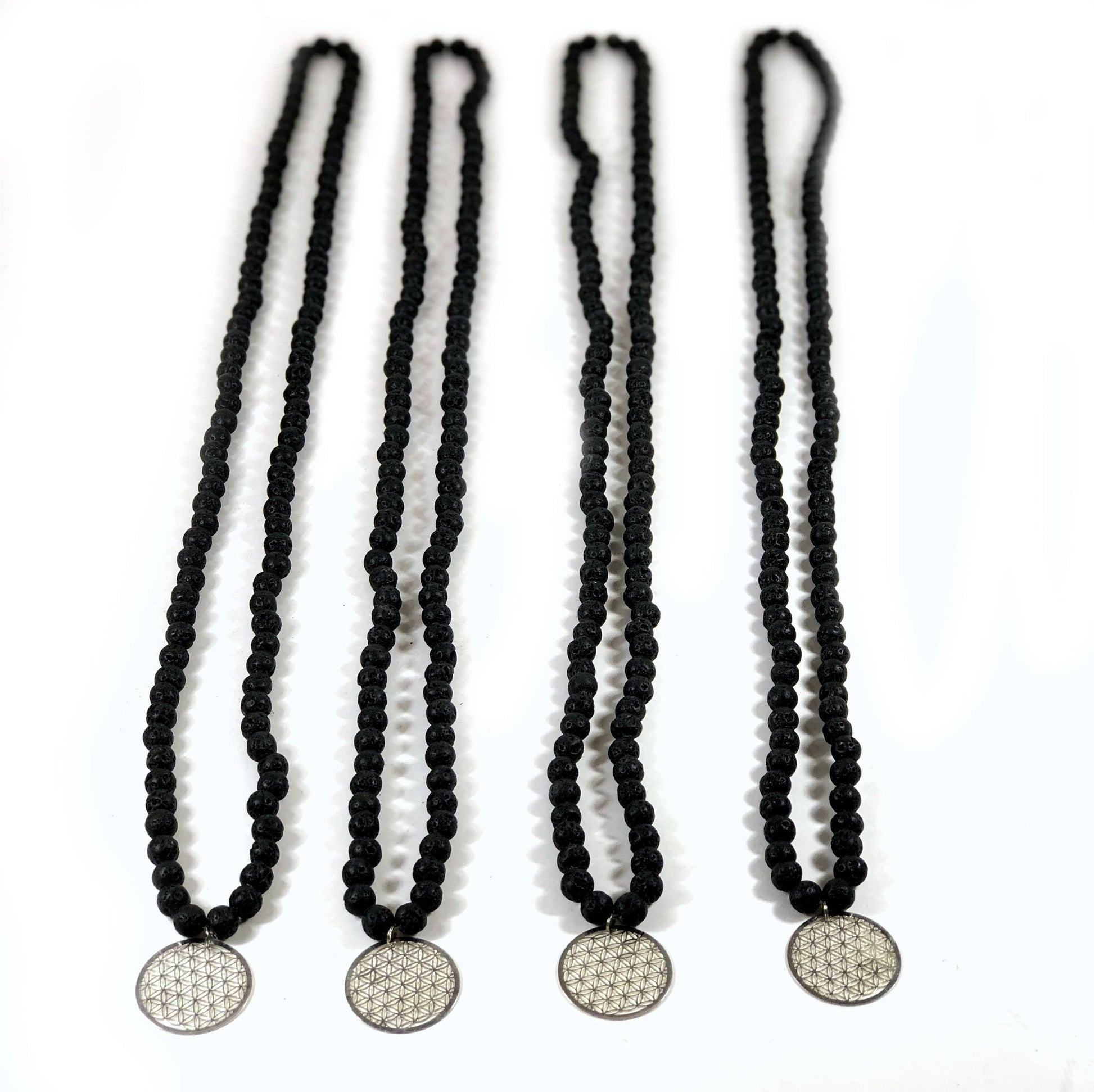 4 Diffuser Necklace Lava Bead with Flower of Life Charm in Silver on White Background.