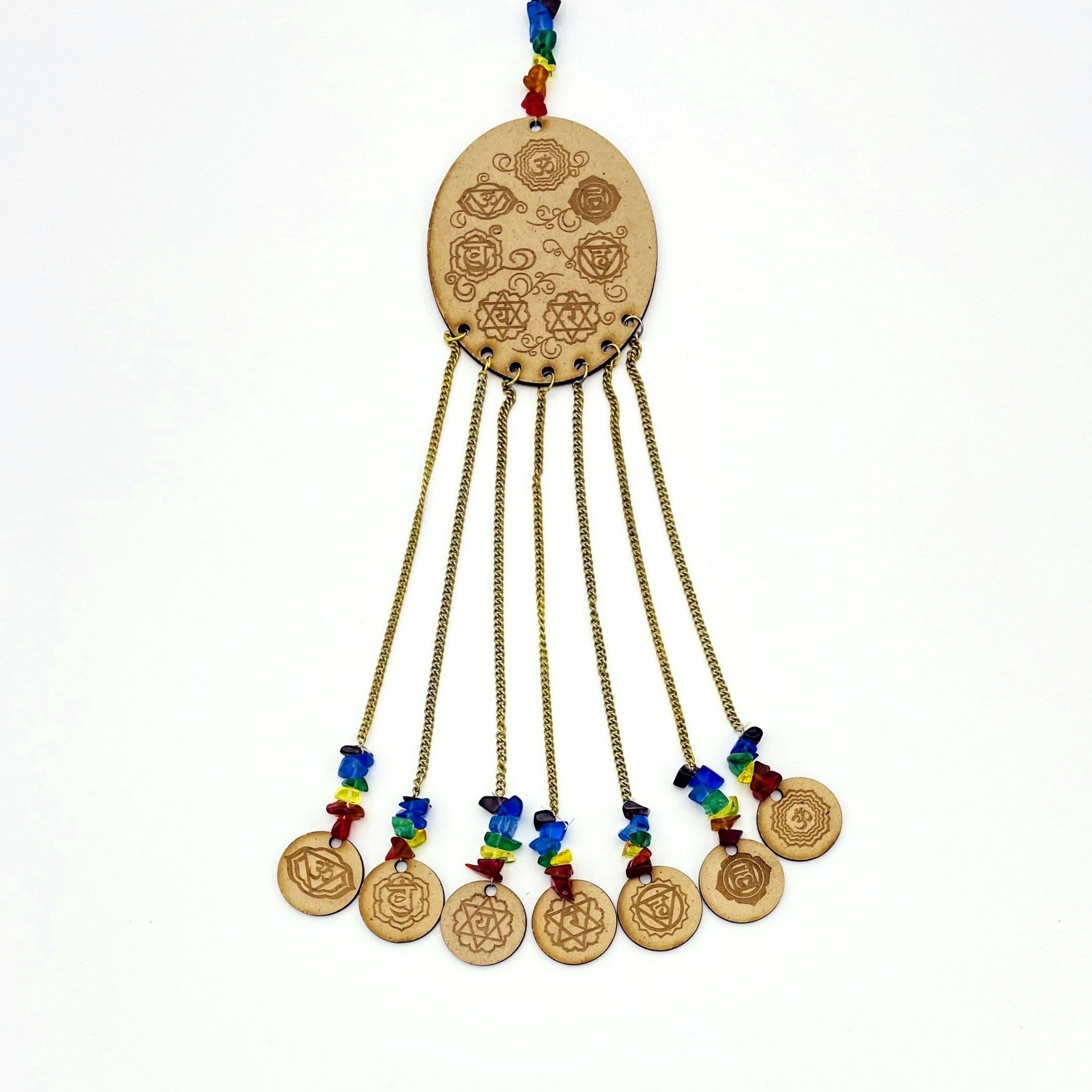 7 Chakra symbols on oval wooden piece with attached mini engraved wood circles on white background.