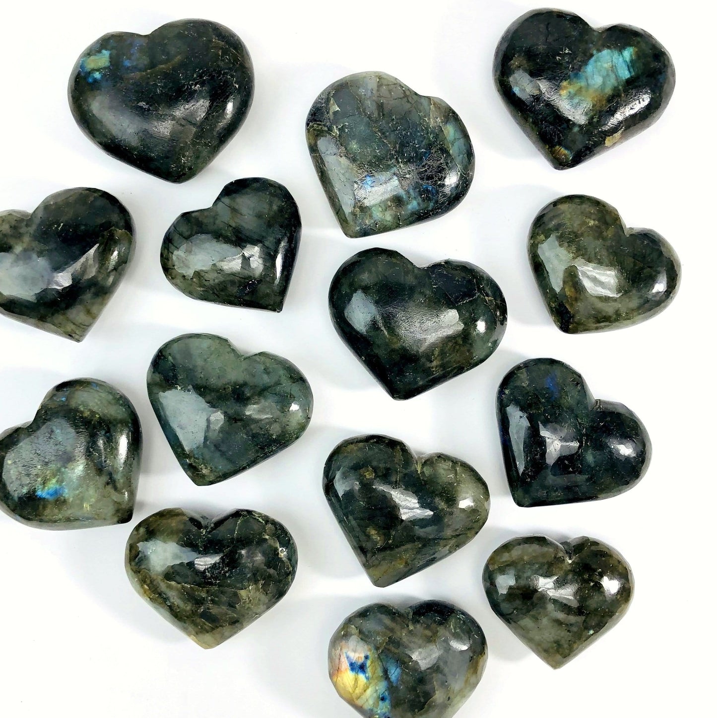 multiple labradorite hearts on white background displaying different sizes 