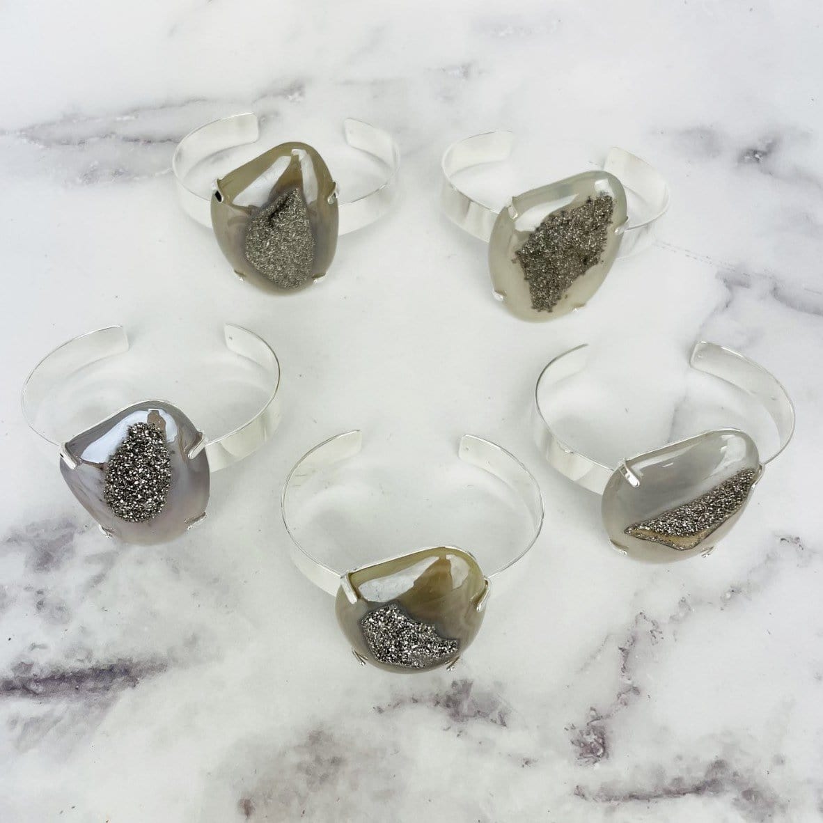 5 titanium druzy angel aura agate bracelets on marble background