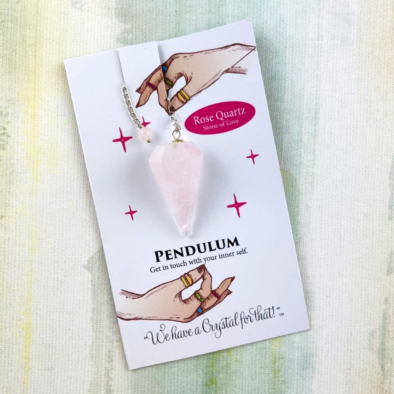 rose quartz crystal pendulum on information card