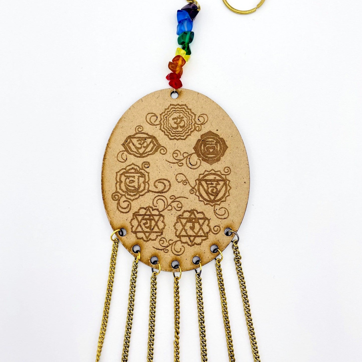 Beautiful Engraved 7 Chakra symbols on oval wooden piece.
