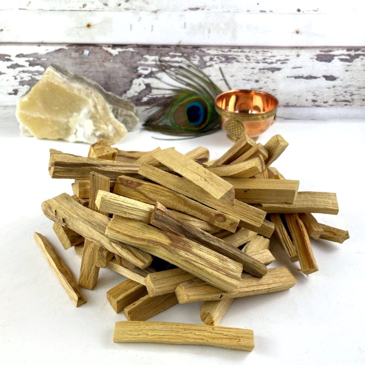 A pile of palo santo sticks on a white background.
