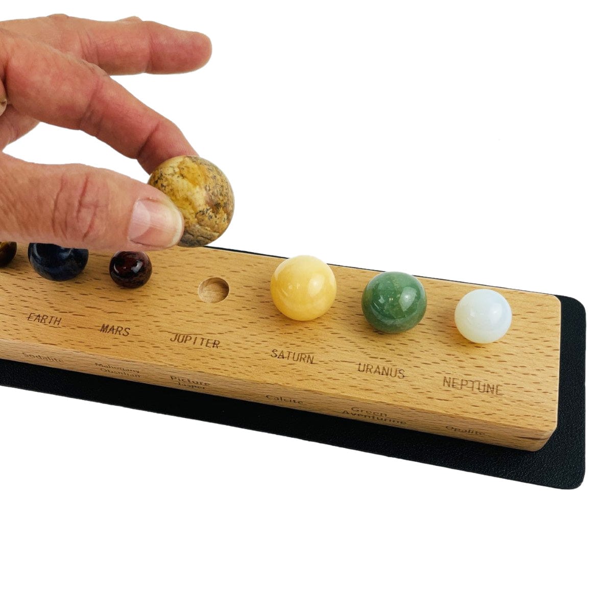 Stone Planets in a Box with a hand lifting one up to show holding area
