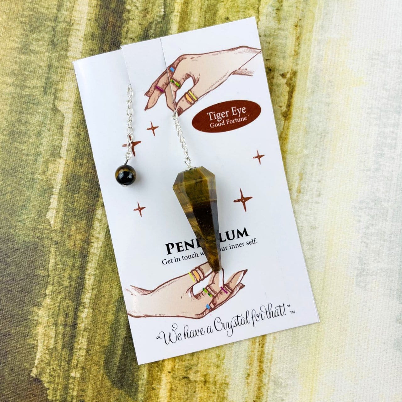 tigers eye crystal pendulum on information card