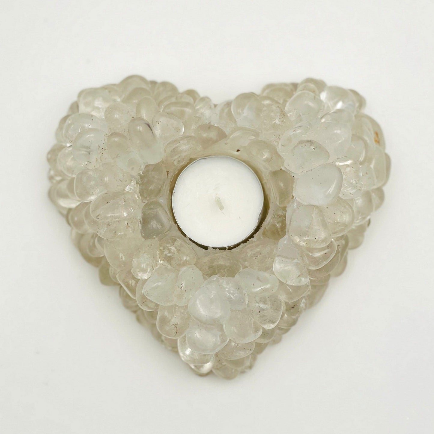 Heart shaped candle holder that is made with crystal quartz tumbled stones that are glued together.