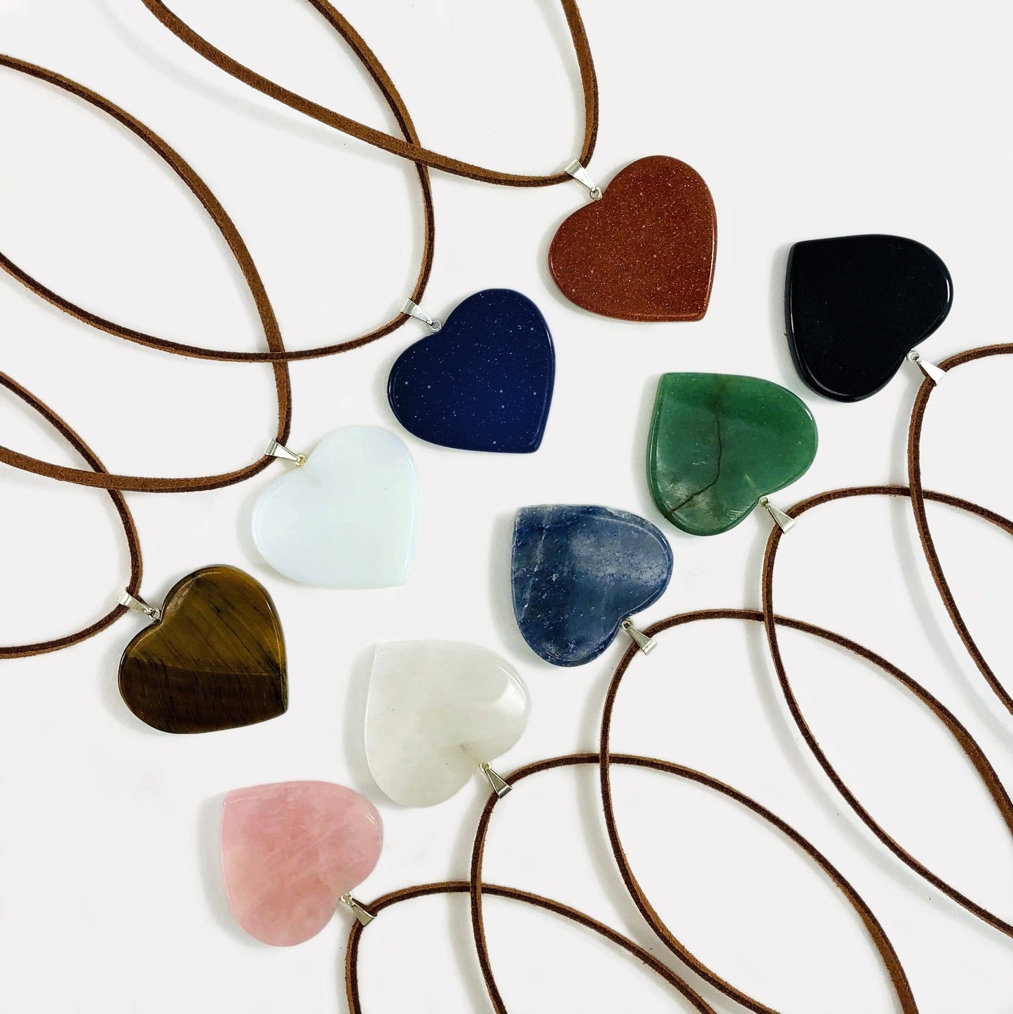 multiple heart slice pendants with silver toned bail with string on them to show as a neckless
