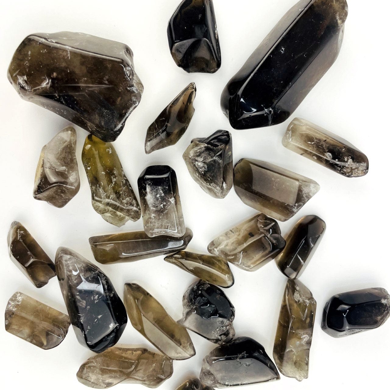 Polished Smoky Quartz Tumbled Stones and Points spread  out on a table