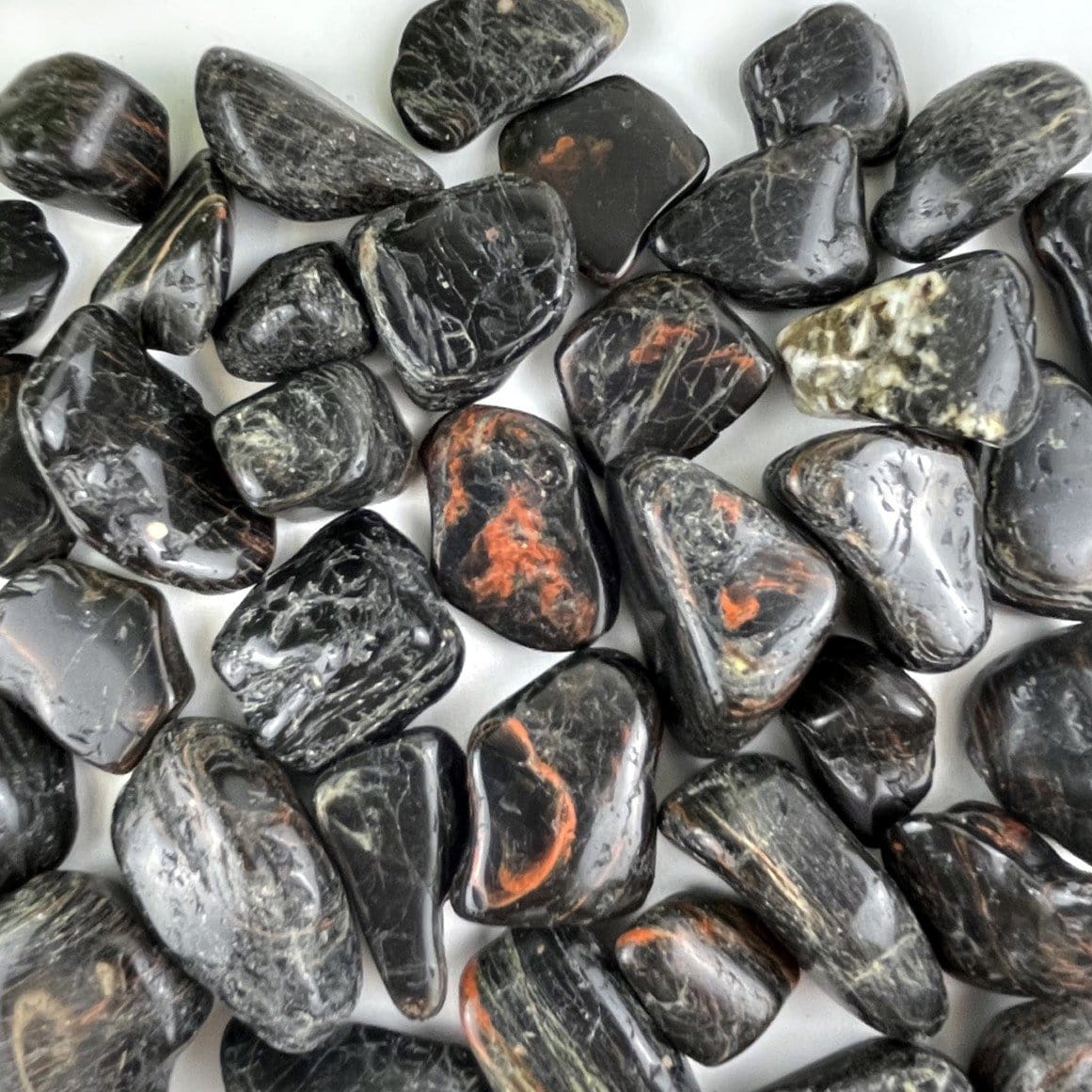 close up of details on black tourmaline with red hematite tumbled stones