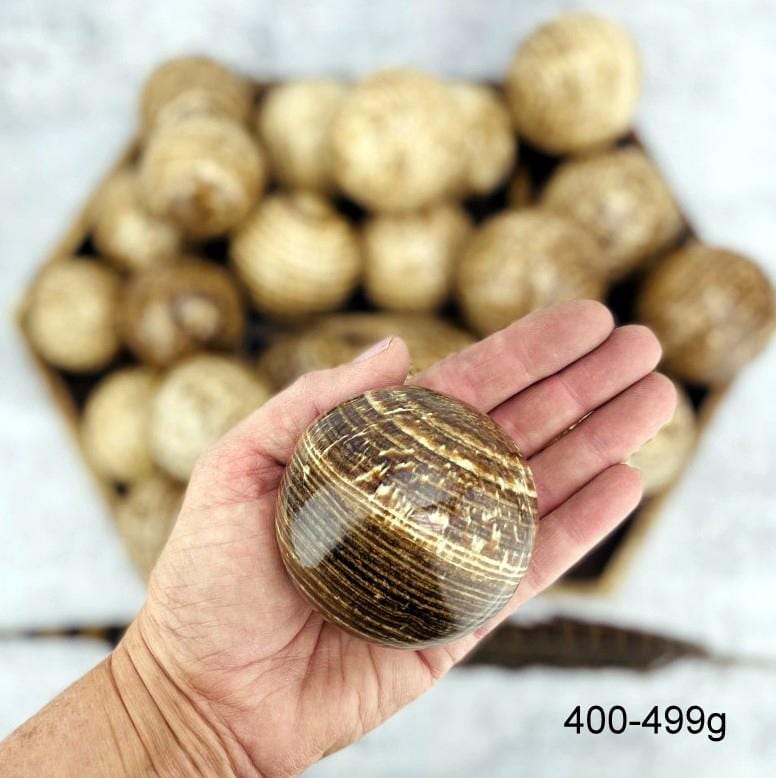 Aragonite Polished Spheres size 400-499g in hand for size reference