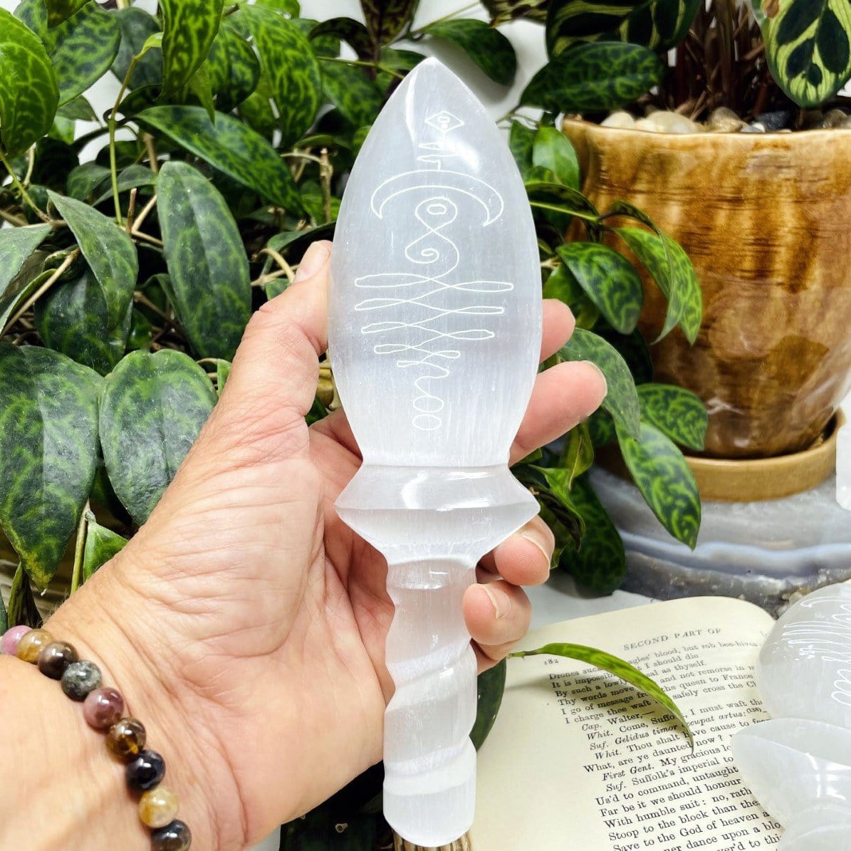 selenite knife twisted handle with unalome engraving in hand for size reference