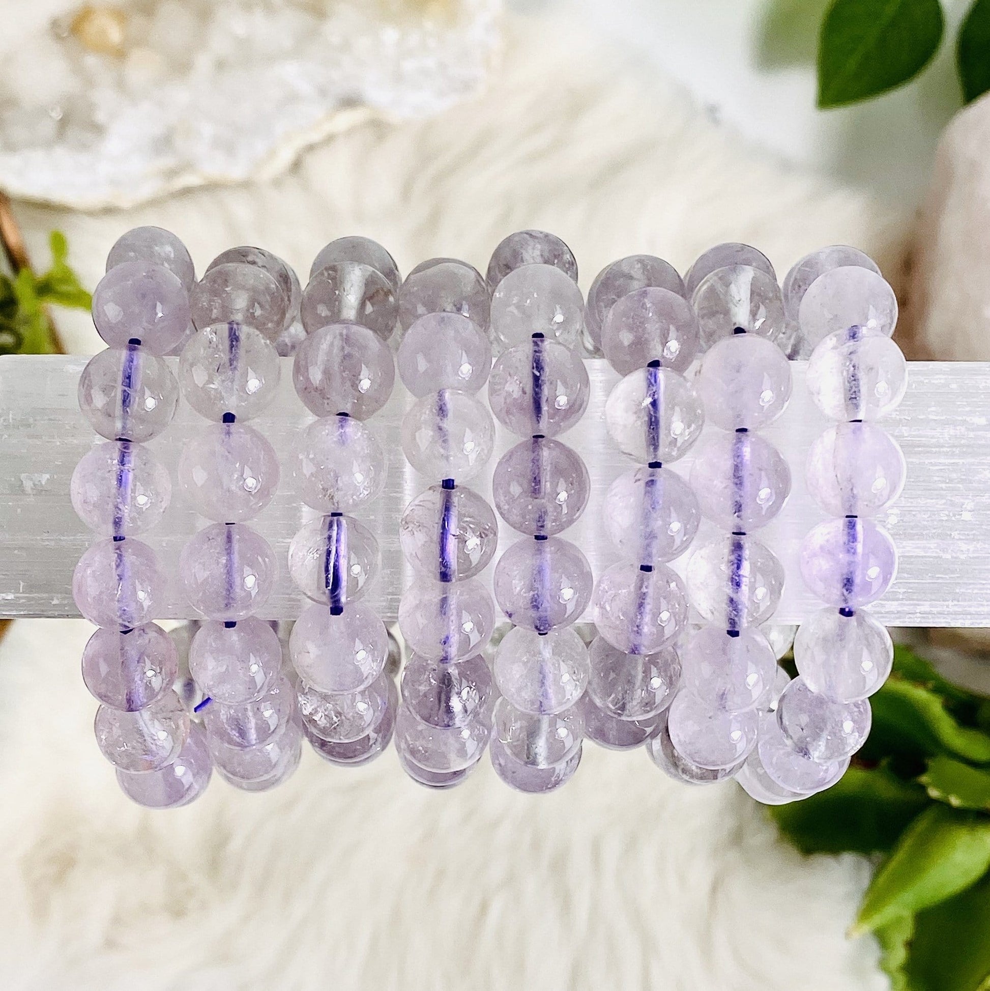 light amethyst round bead bracelets on a cylinder