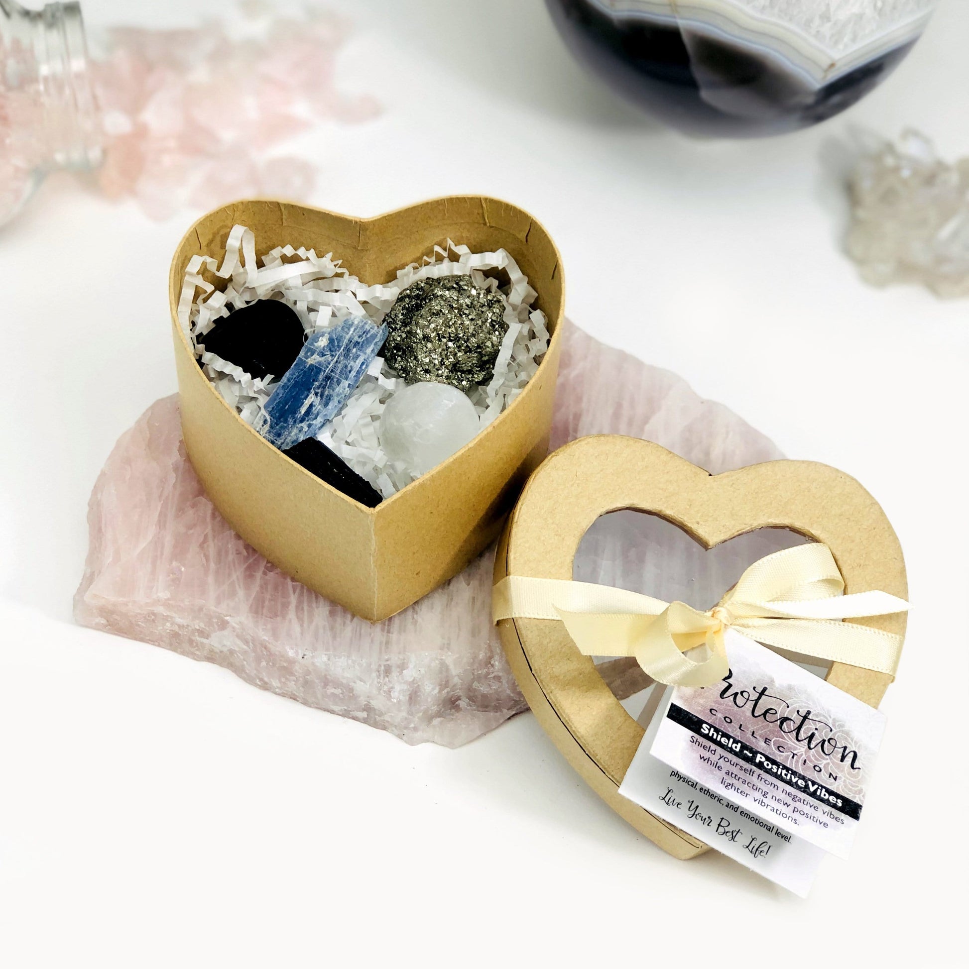 heart shaped box is open displaying the gemstones that come inside on a platter with a white background