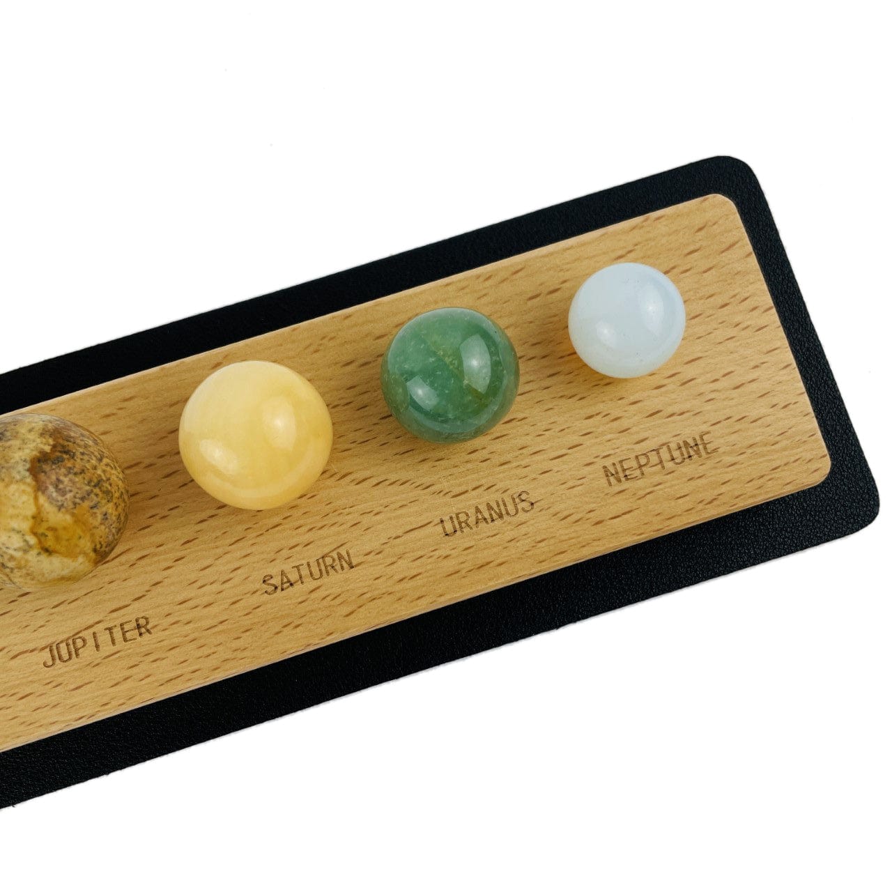 up close of 4 stone spheres with planet name on wood