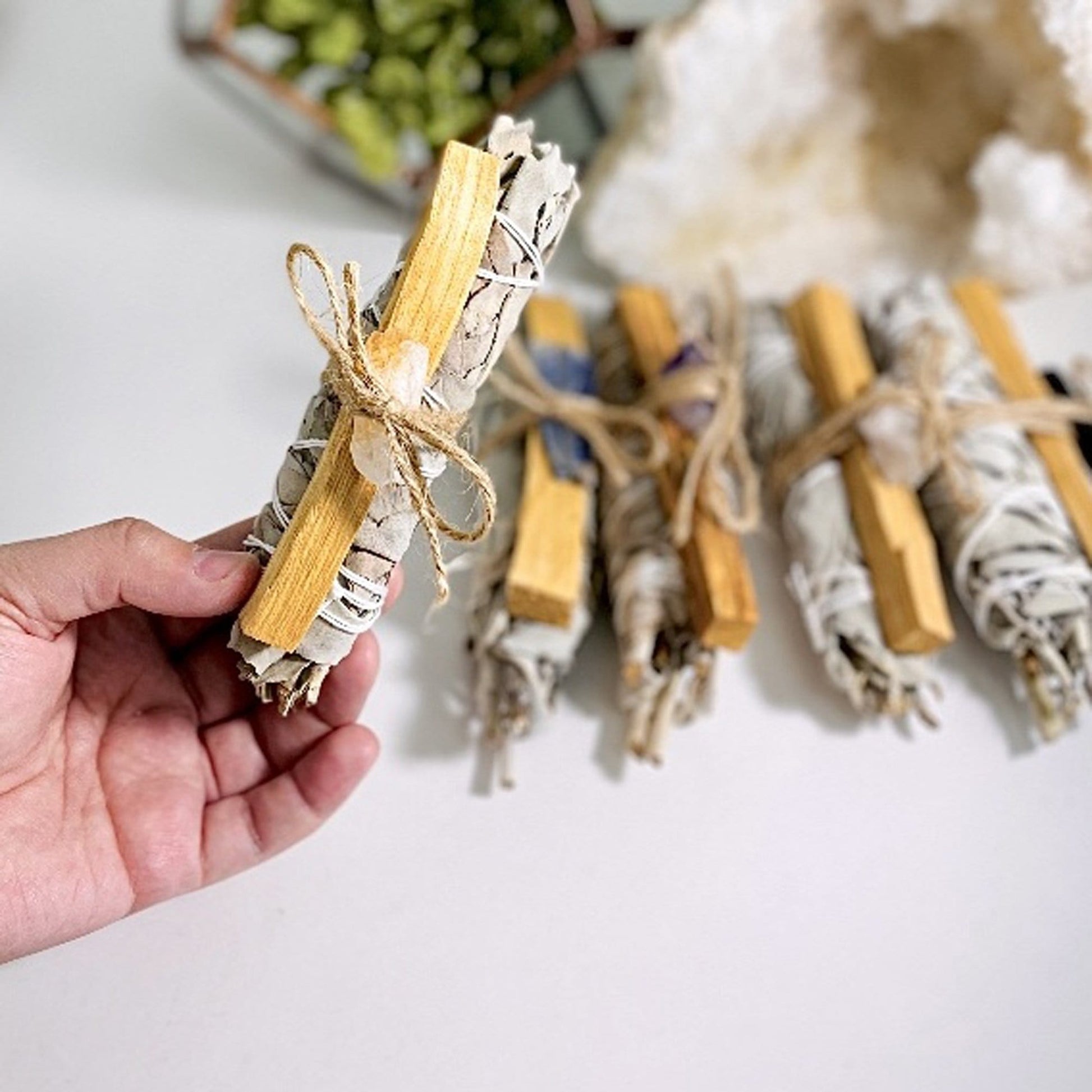 sage bundle palo santo with citrine in hand for size reference