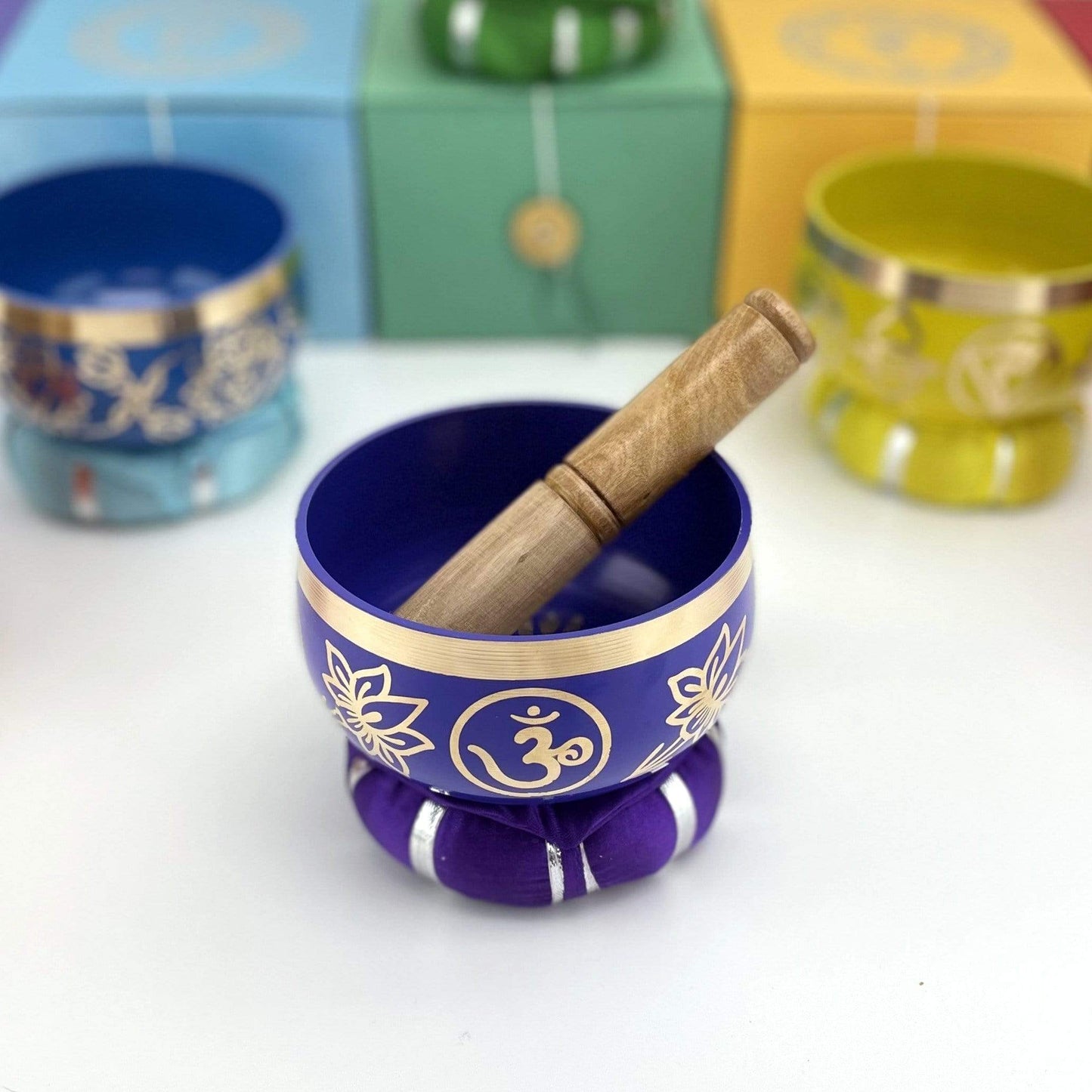 Purple Brass Tibetan Chakra Singing Bowl on a pillow with a mallot inside