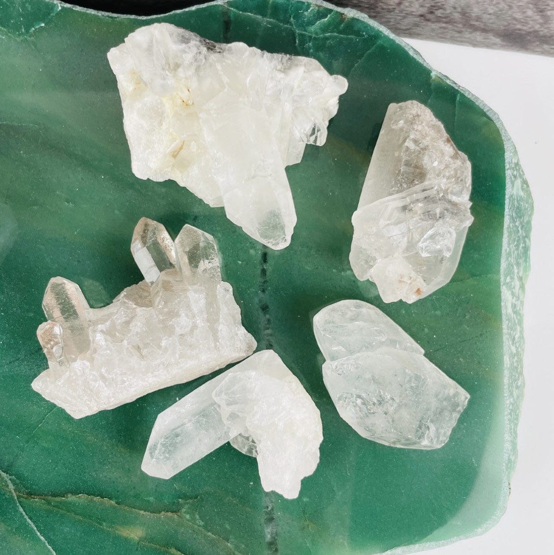 5 crystal clusters from an organza bag on a green background