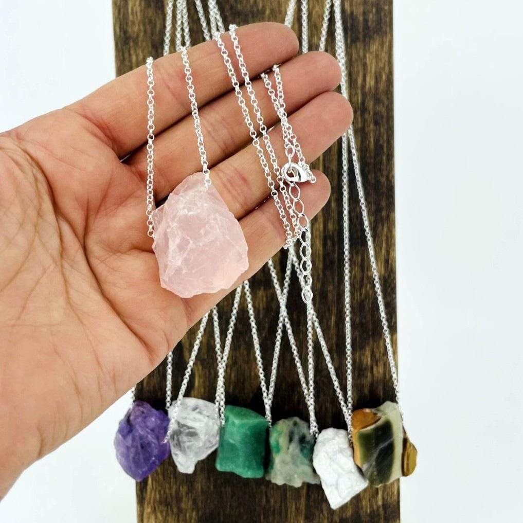Hand holding Healing Stone Necklace with others in the background