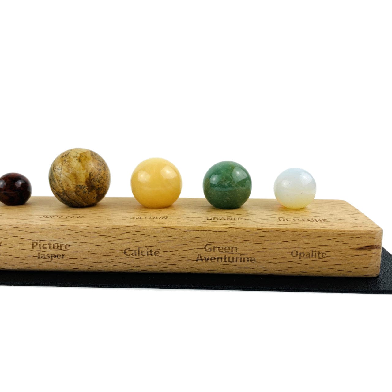 Close up of 5 of the stone spheres representing planets on a wood base with stone names