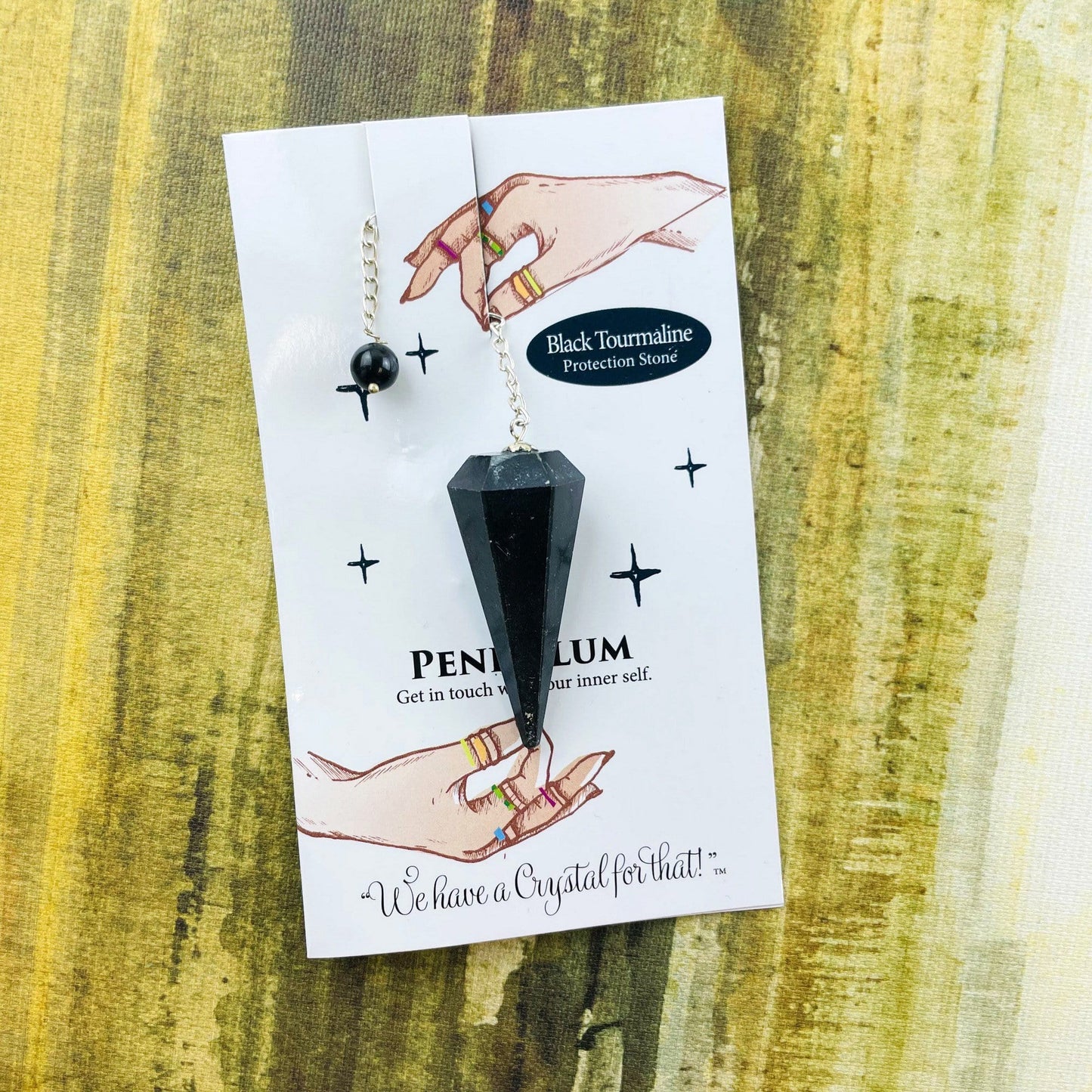 black tourmaline crystal pendulum on information card