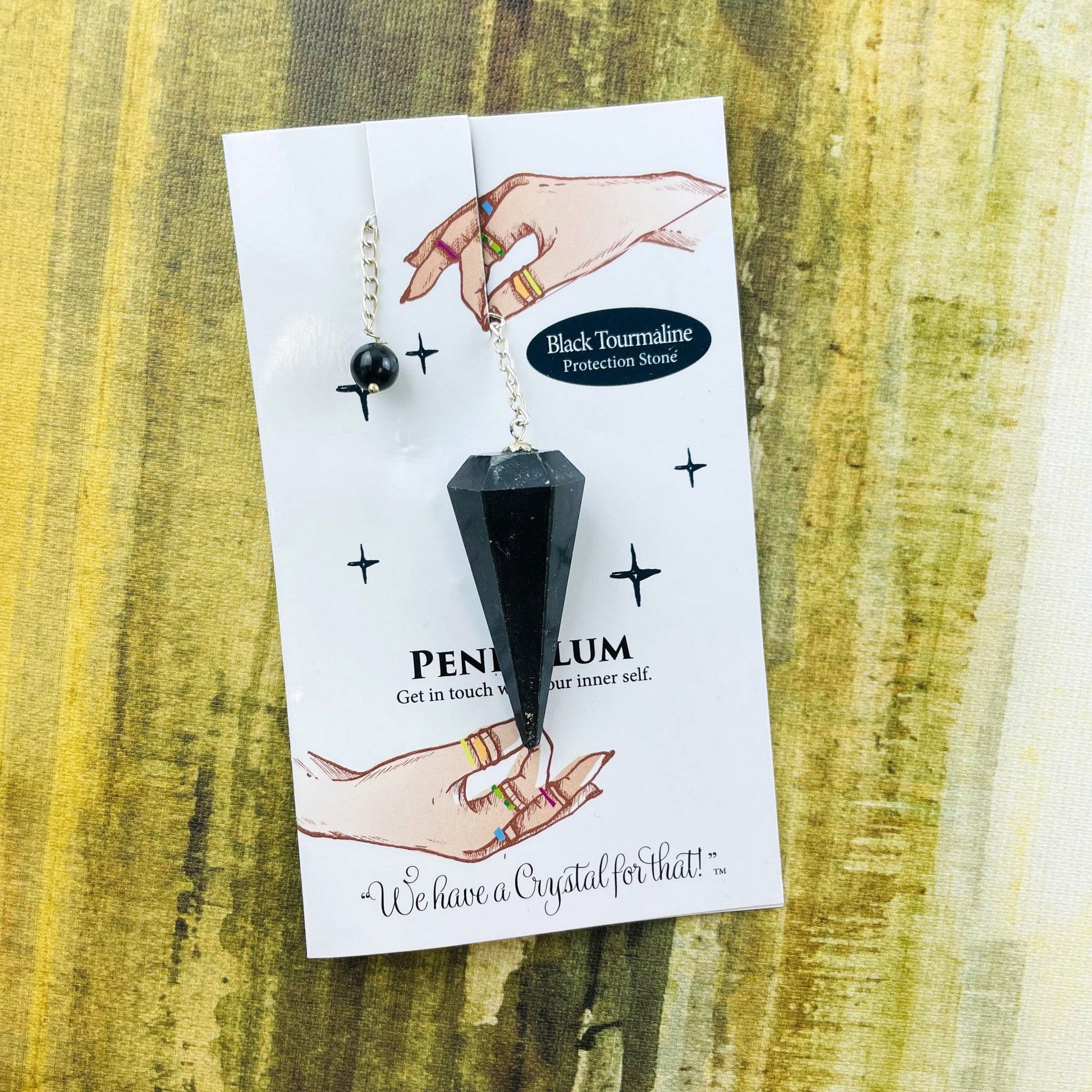 black tourmaline crystal pendulum on information card
